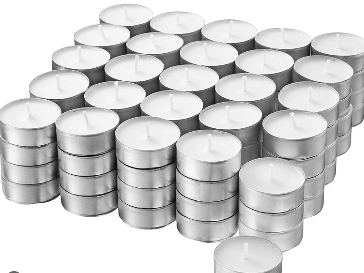 Viele Teelichter sind in mehreren Reihen angeordnet. Die Kerzen sind in silbernen Metallbehältern, mit dem weißen Wachs und einem kleinen Docht sichtbar, was eine ordentliche und symmetrische Anordnung zeigt.